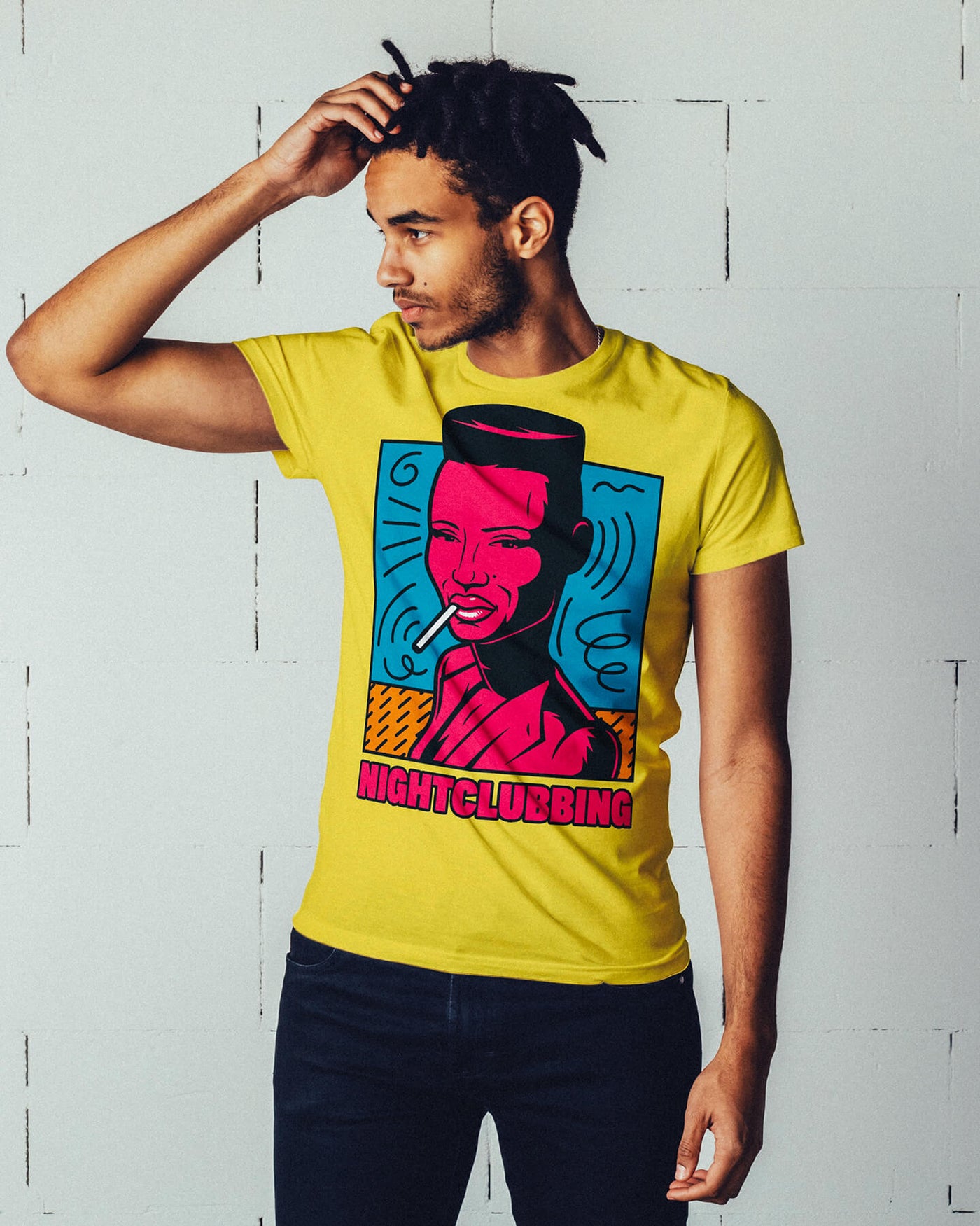 Young Black male model sporting braids while wearing Gllamazon's "Grace Jones Nightclubbing" T-Shirt in Yellow.