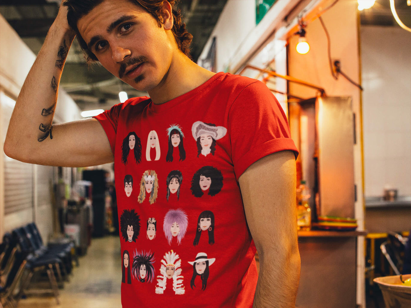 Guy with moustache grabbing his hair while wearing Gllamazon's Turn Back Time Cher T-Shirt inside an urban market