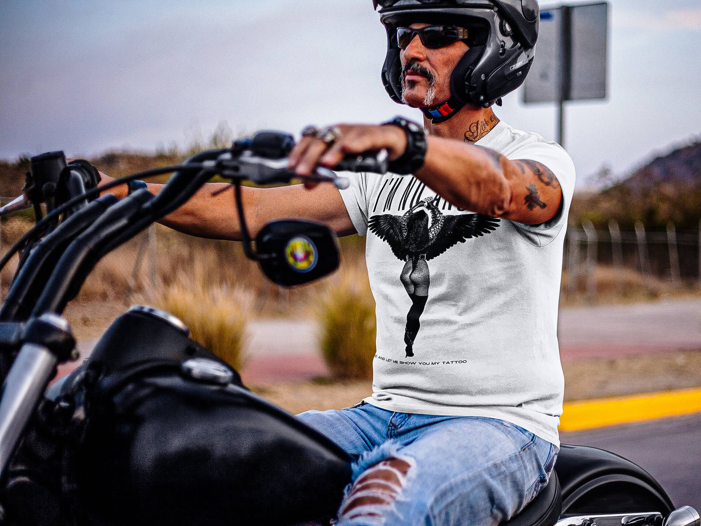 Biker riding a motorcycle, clad in 'I'm No Angel Cher' T-shirt by Gllamazon, exuding a sense of freedom and adventure.
