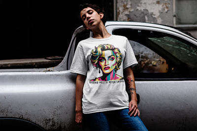A girl leaning against an old car, wearing a 'Second Best Is Never Enough' Madonna unisex t-shirt by Gllamazon. Color: White.