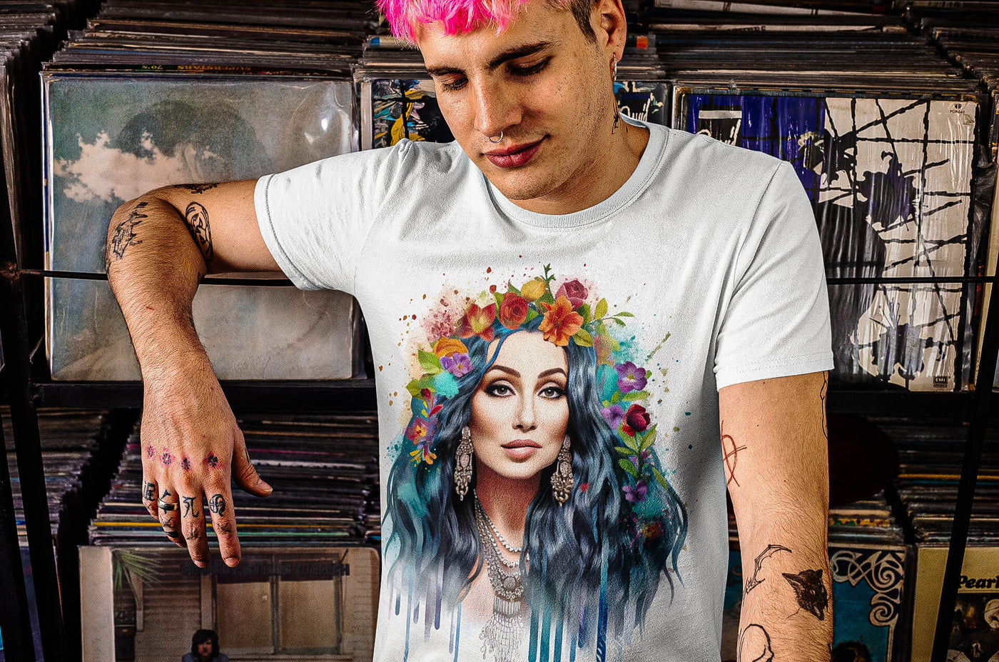 Tattooed young man at a record store wearing Gllamazon's Cher-ry Blossom Cher T-shirt. Color: White.