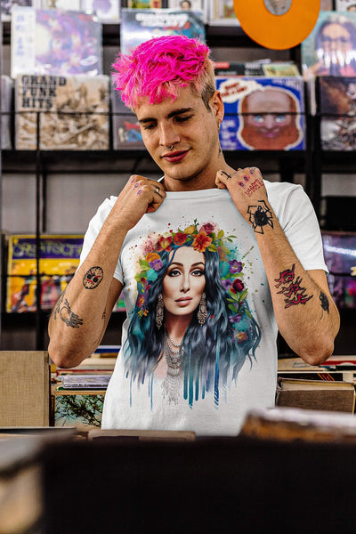 Tattooed young man with pink hair at a vinyl record store, wearing Gllamazon's Cher-ry Blossom Cher T-shirt. Color: White.