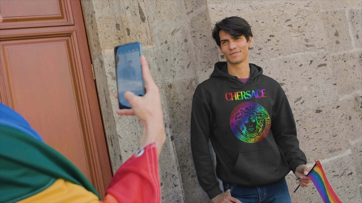 Video of a man wearing the Cher CHERSACE Hoodie by Gllamazon, posing for a picture at the Pride parade