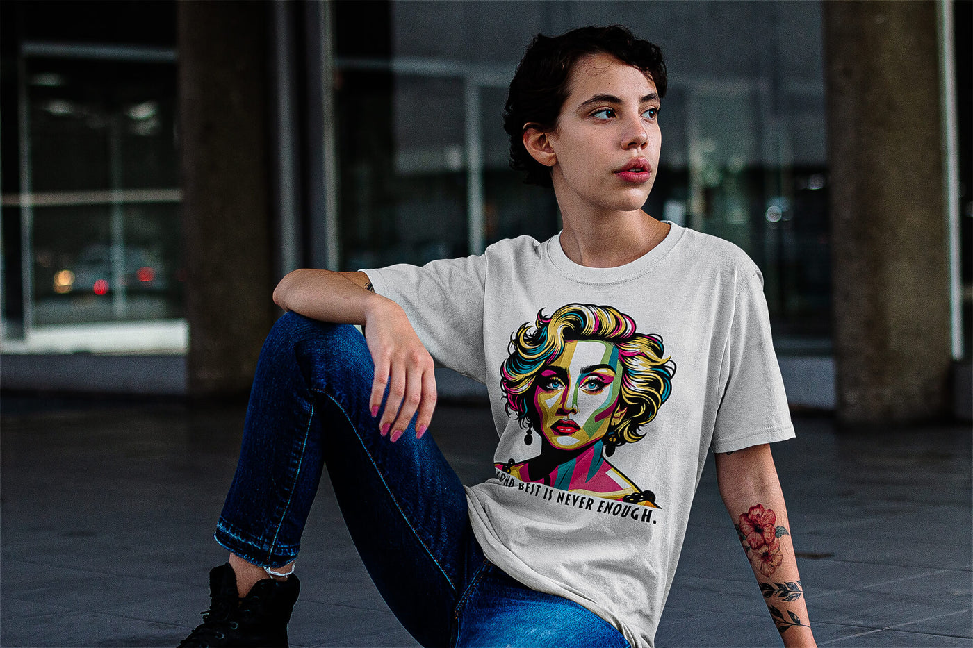 A woman with tattoos wearing a 'Second Best Is Never Enough' Madonna unisex t-shirt by Gllamazon. Color: White.